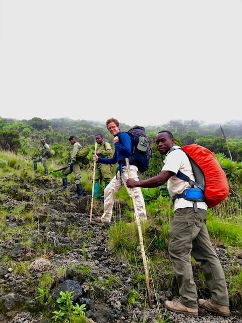 Guest, rangers and a porter trekking up Mt Nyiragongo